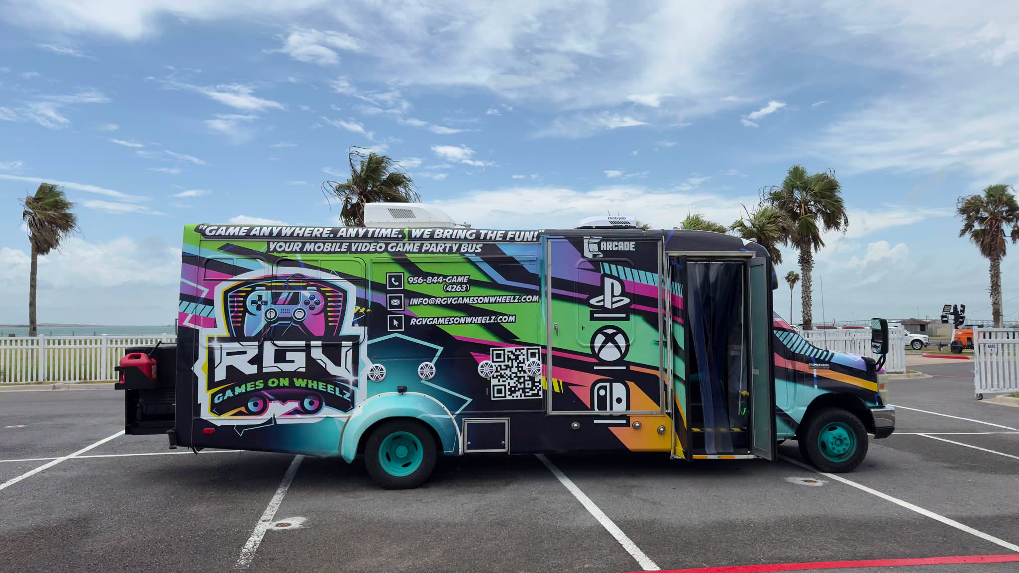 The RGV Games on Wheelz party bus parked by the water in South Texas, doors open and ready for an event