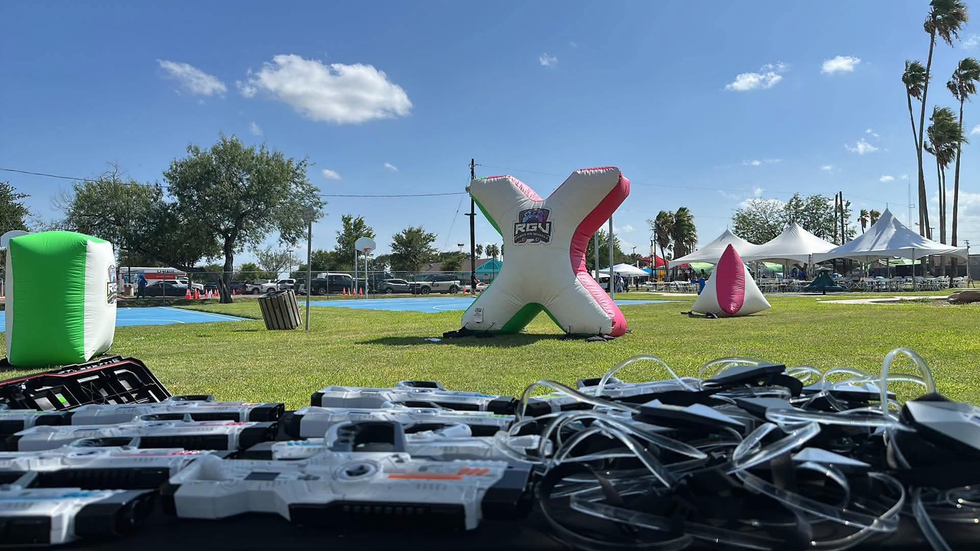 Laser tag equipment and inflatable bunkers set up on an open field before an RGV Games on Wheelz event