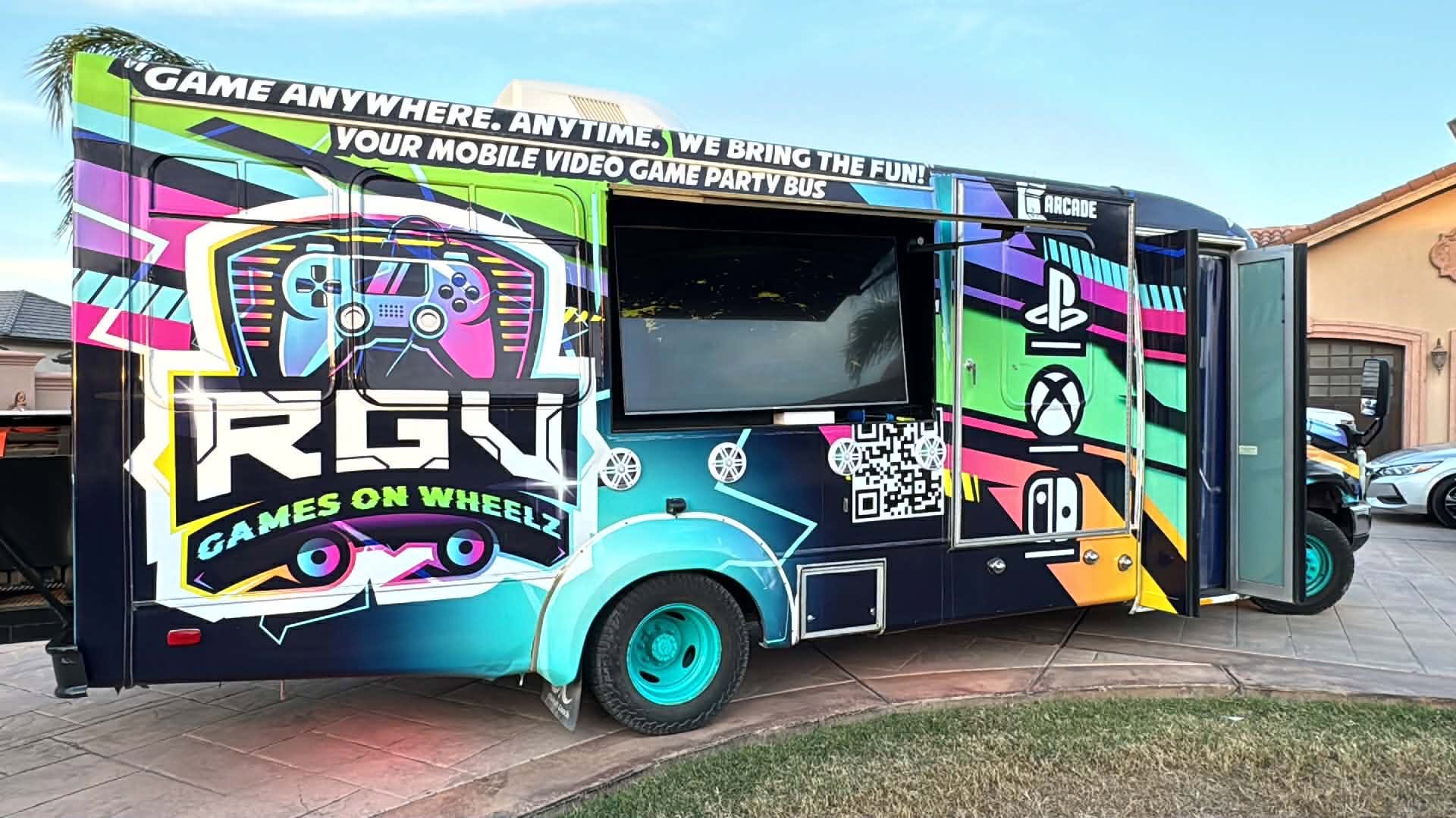 The RGV Games on Wheelz mobile gaming bus parked in a McAllen driveway, wrapped in full graphics with its outdoor screen mounted on the side